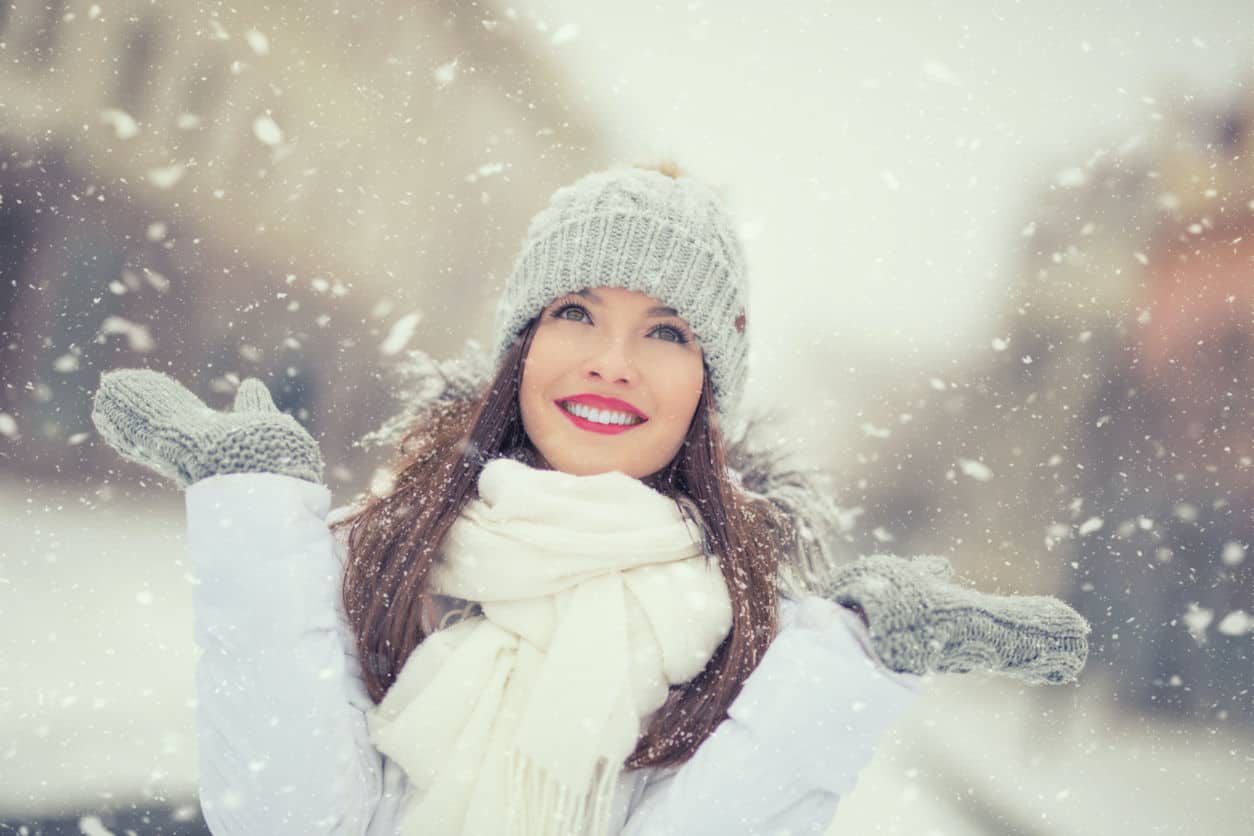 Beautiful smiling young woman in warm clothing. The concept of portrait in winter snowy weather