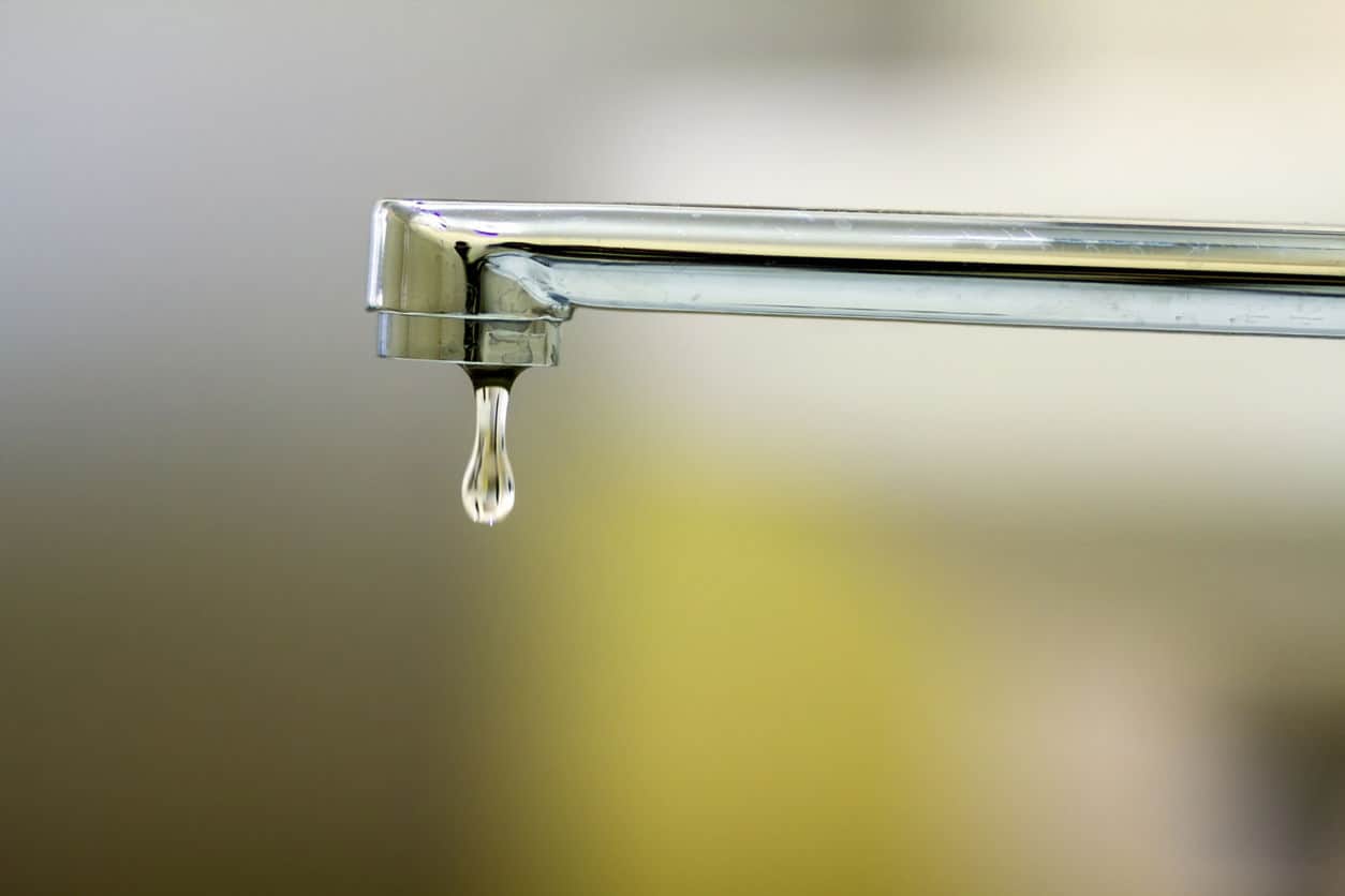 Close-up of faucet with turned drop water in modern bathroom. Horizontal crop with shallow depth of field