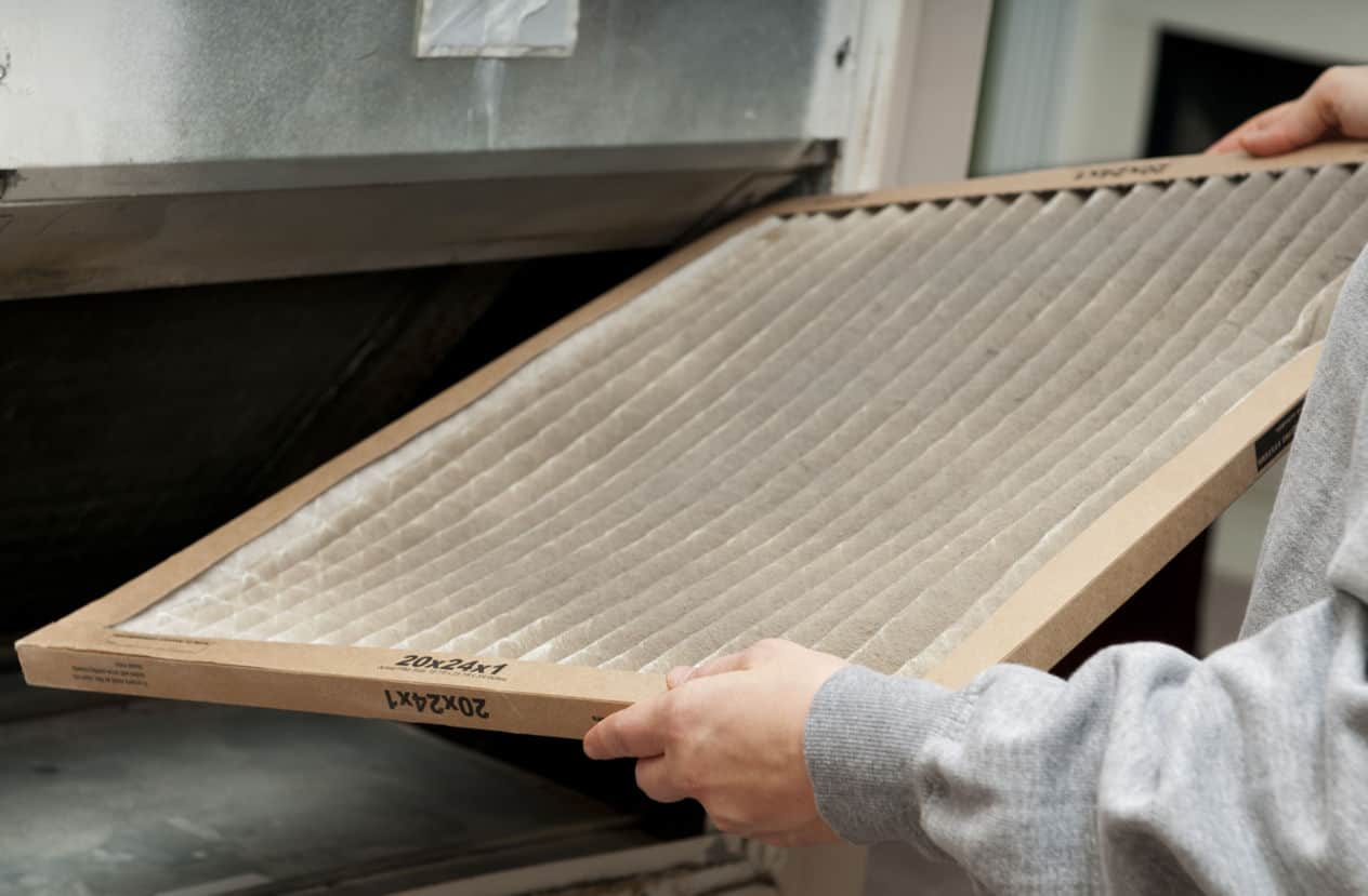 Home owner changing their dirty air filter.