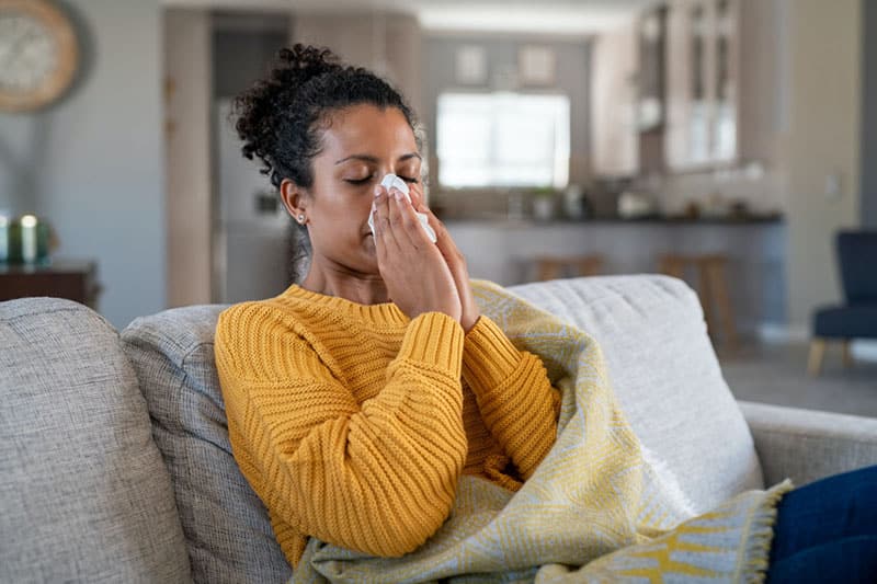 Woman blowing nose due to poor indoor air quality
