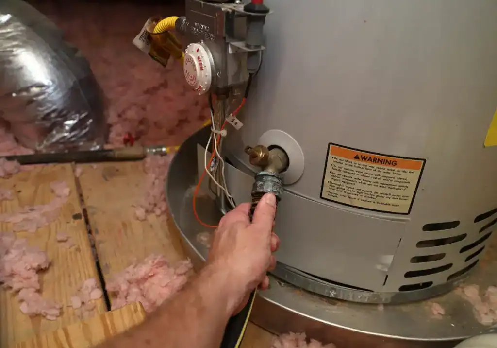 man holding valve on water heater drain