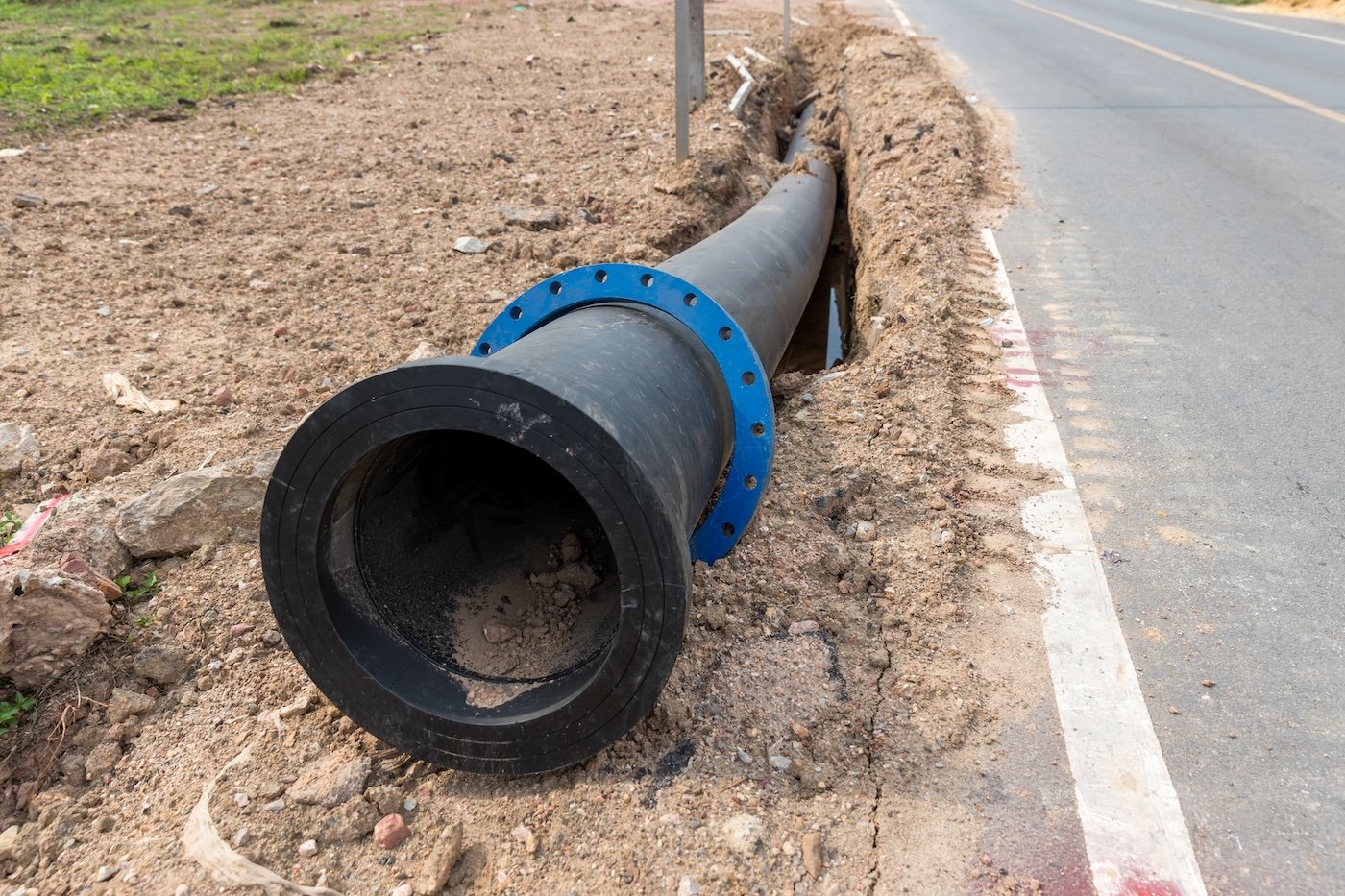 Construction Site With New Water Pipes In The Ground. Sewer Pipes To Repair Or Restore In Street City