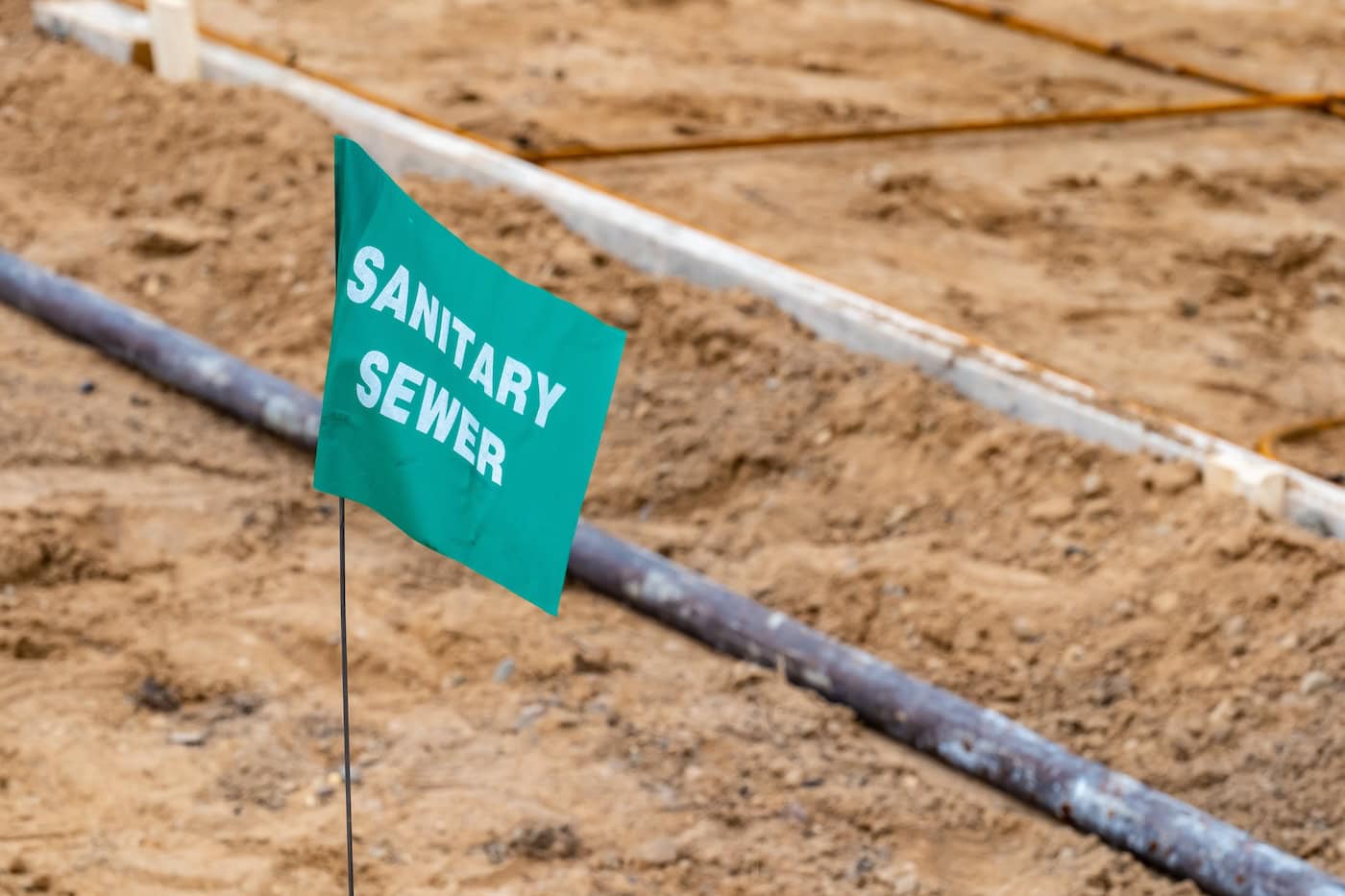 A Small Flag Warning Of An Underground Sewer Line At A Construction Site.