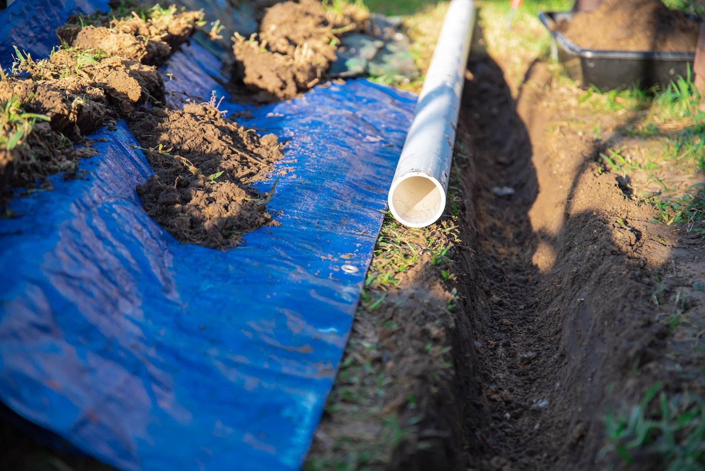 Selective Focus Plastic Sewage Pipes Pvc, Blue Tarp With Dirt, Black Mixing Tub, Pipe Ready To Laying, Buried In Ground Trench, Rainwater Drainage Residential House, Dallas, Texas, Usa
