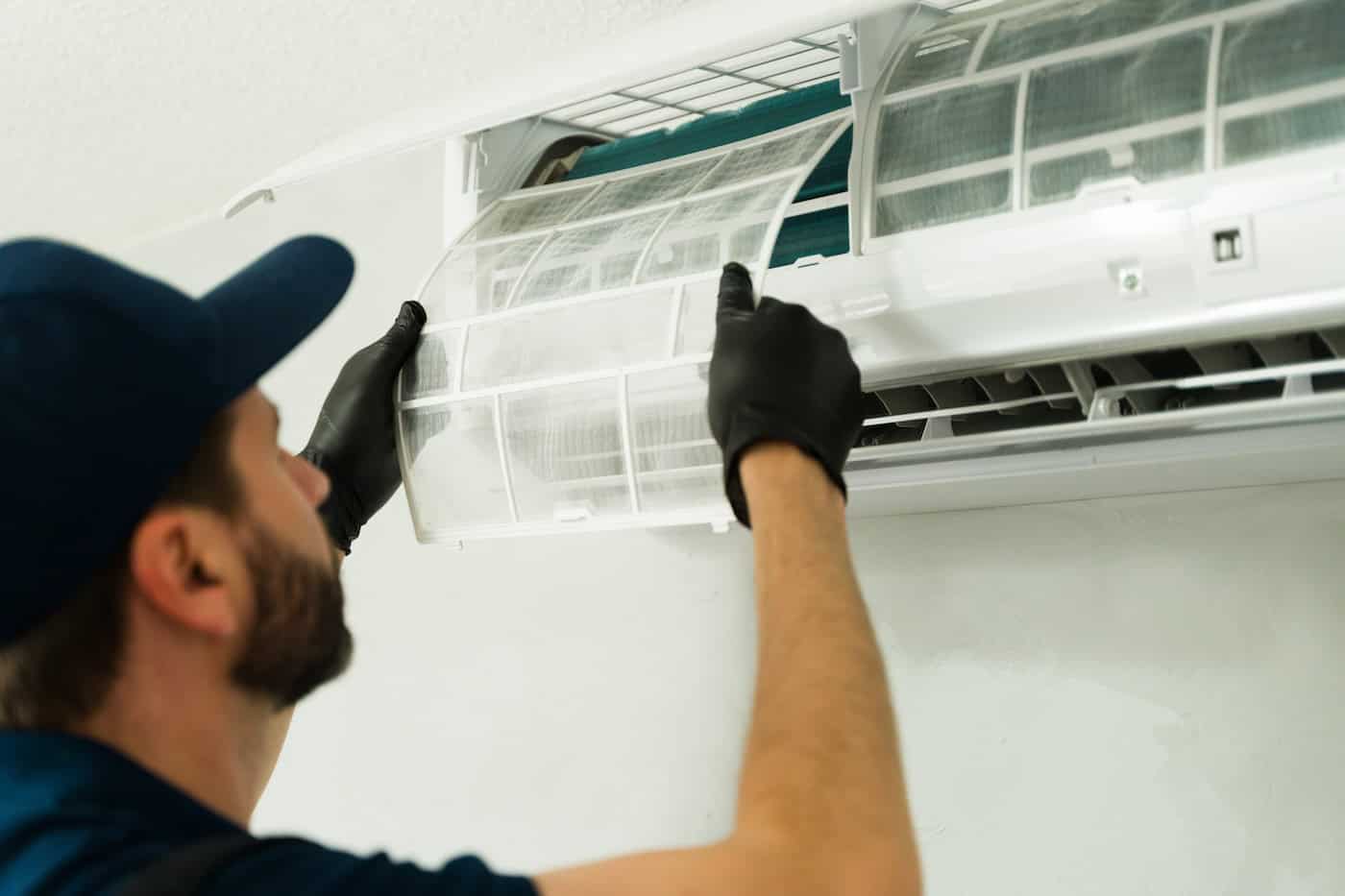 Closeup Of A Technician Cleaning Air Conditioning Filter During Maintenance Service