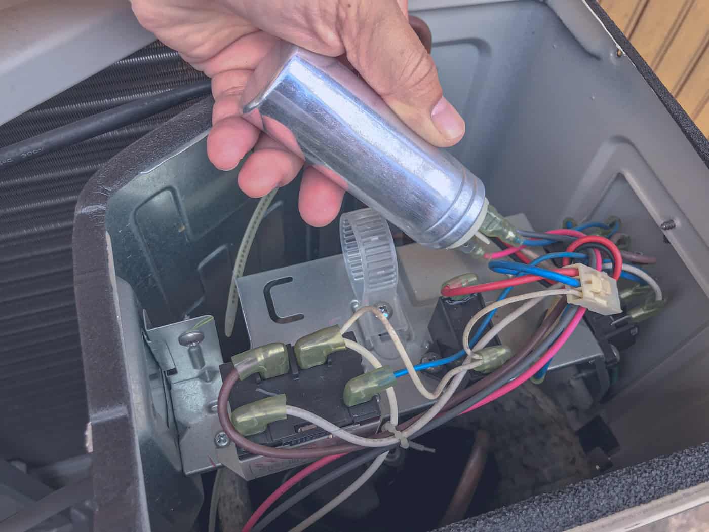 Air Conditioner Repair By Technician. The Technician Replace The Capacity Run Of Airconditioner. Hand Holding The Capacitor Run.