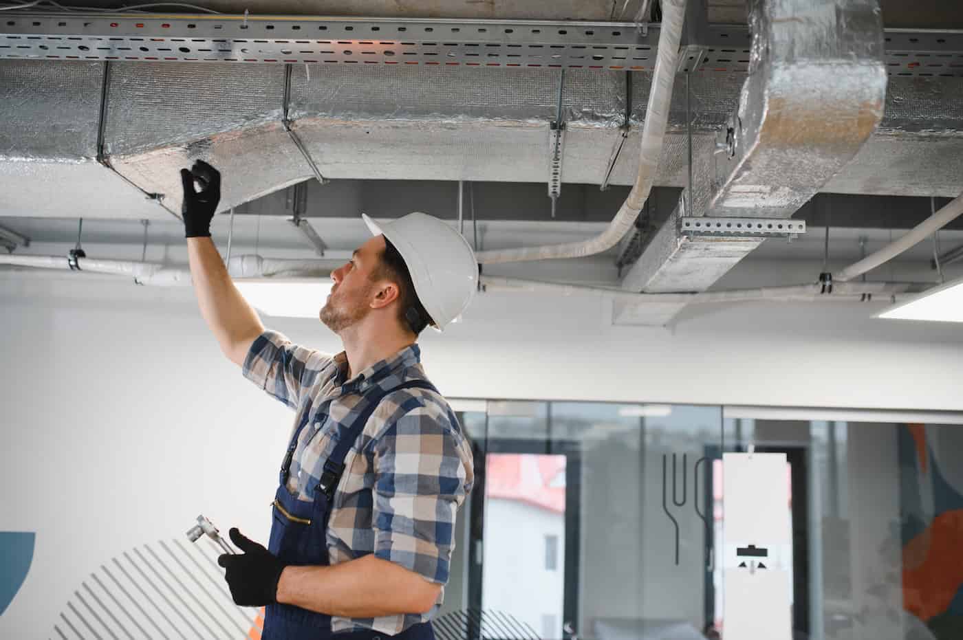 Hvac Technician Installing Ventilation System In Building Under Construction