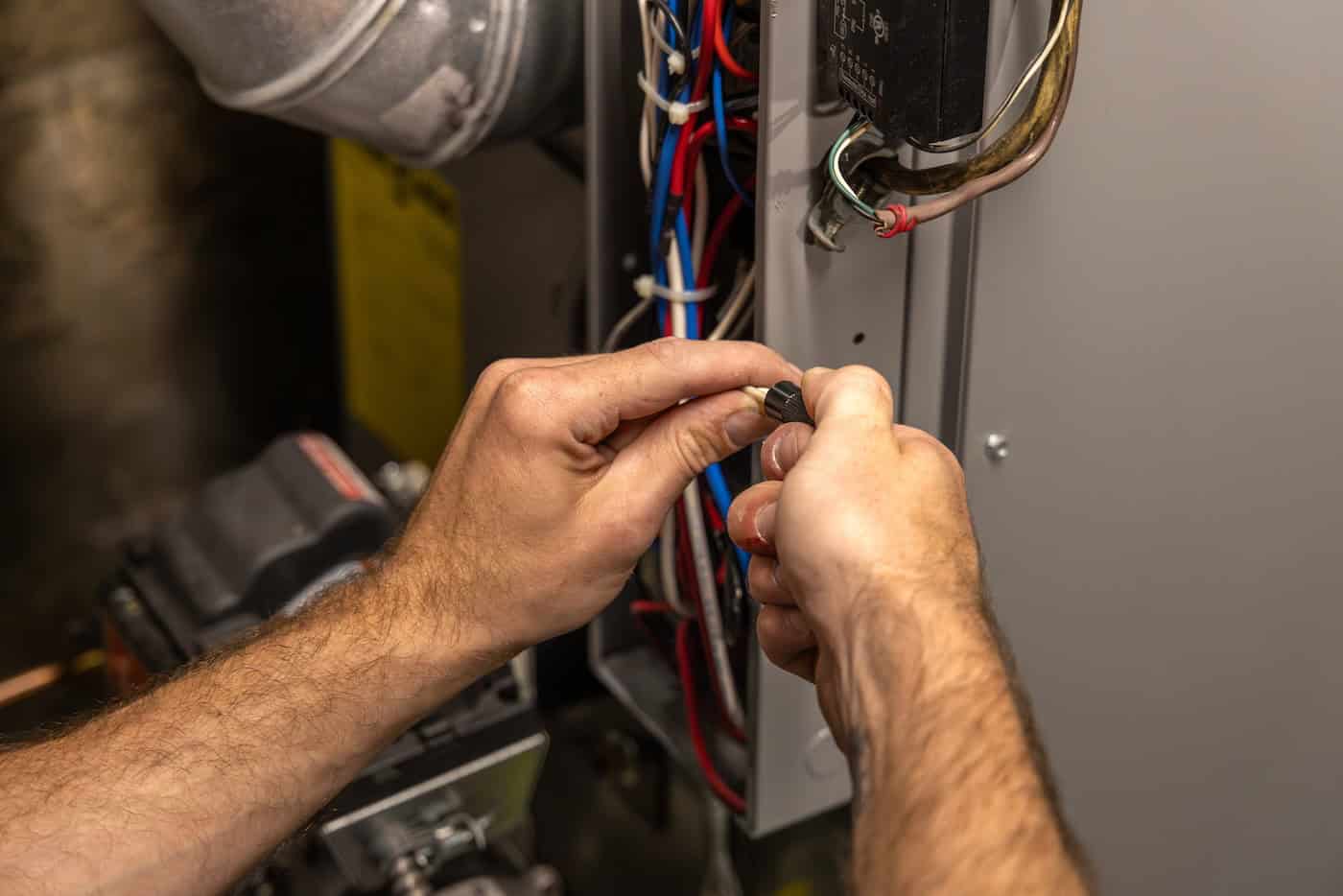Electrician Connecting Wires Inside Electrical Panel Installing Modern Heating System