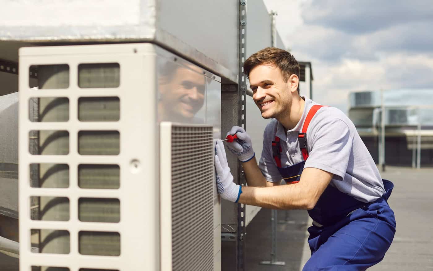Young Repairman Installing And Repairing Ventilation System And Air Conditioner On The Rooftop.