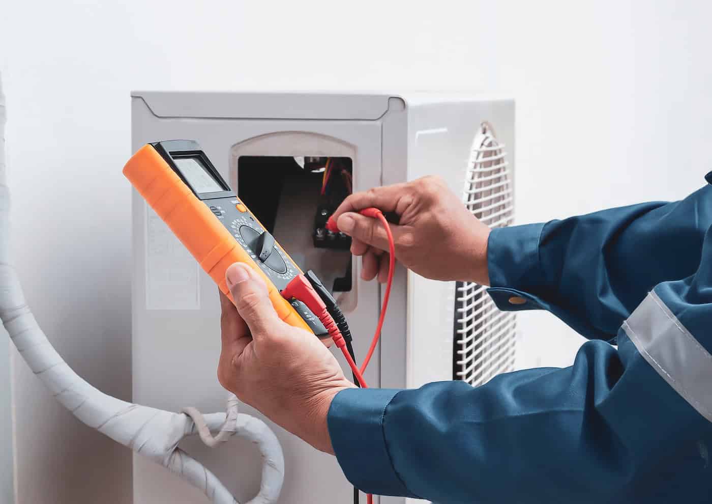 Repairman Holding Multimeter To Check Air Conditioner System