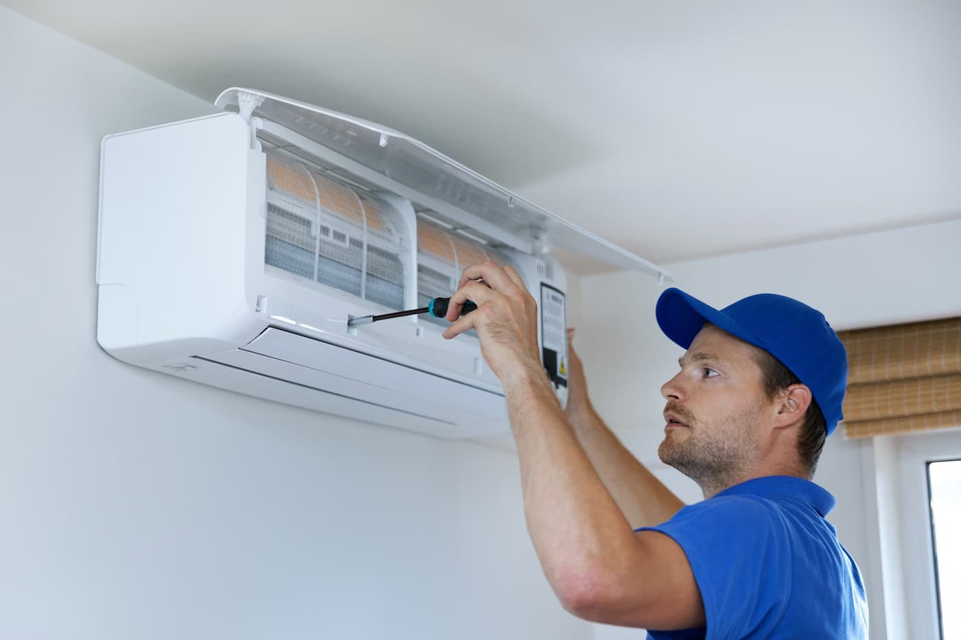 Hvac Services   Technician Installing Air Conditioner On The Wall At Home