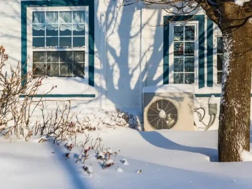 Heat pump outside covered in snow